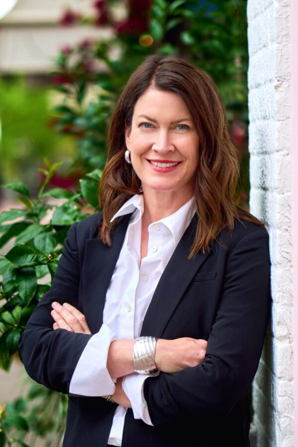 Smiling woman in black blazer outdoors