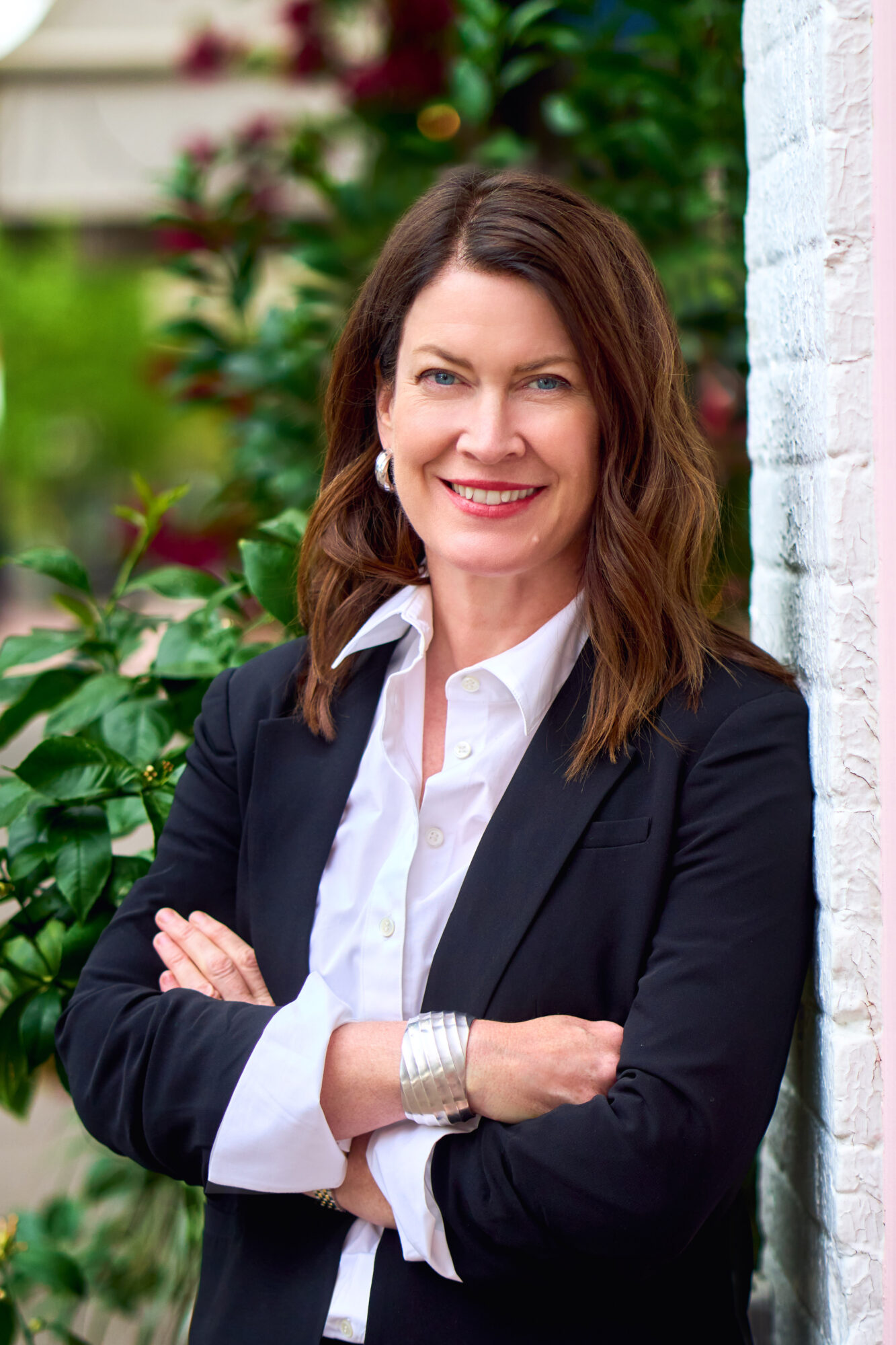Smiling woman in black blazer outdoors
