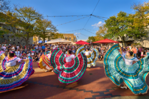 Traditional dancers performing in colorful dresses outdoors.
