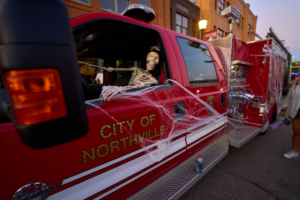 Fire truck decorated with skeleton and cobwebs.