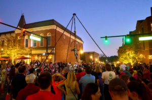 Crowd enjoying street performer on evening downtown.
